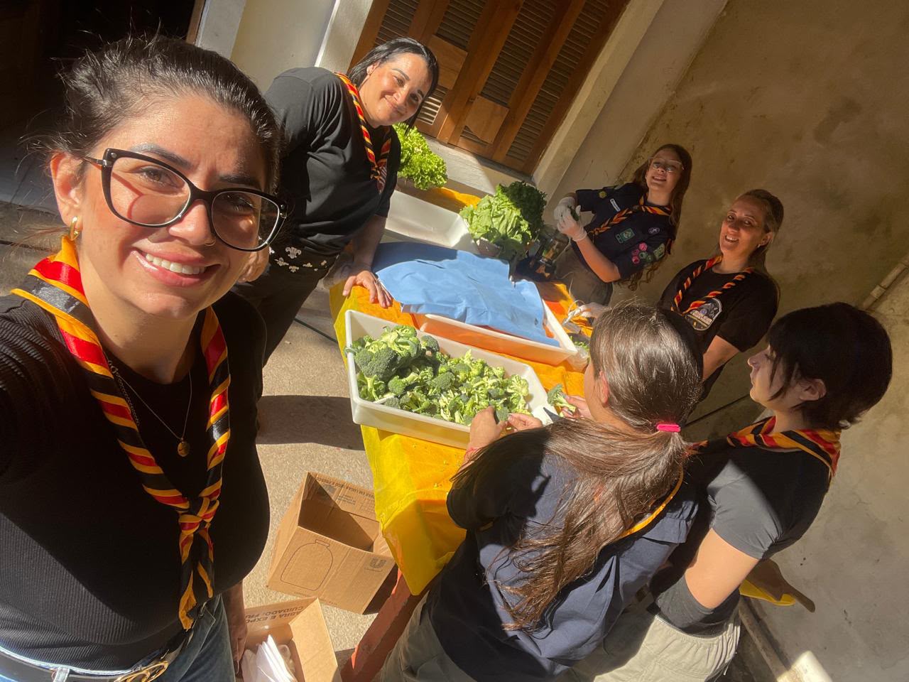 Escoteiras preparando alimentos em atividade