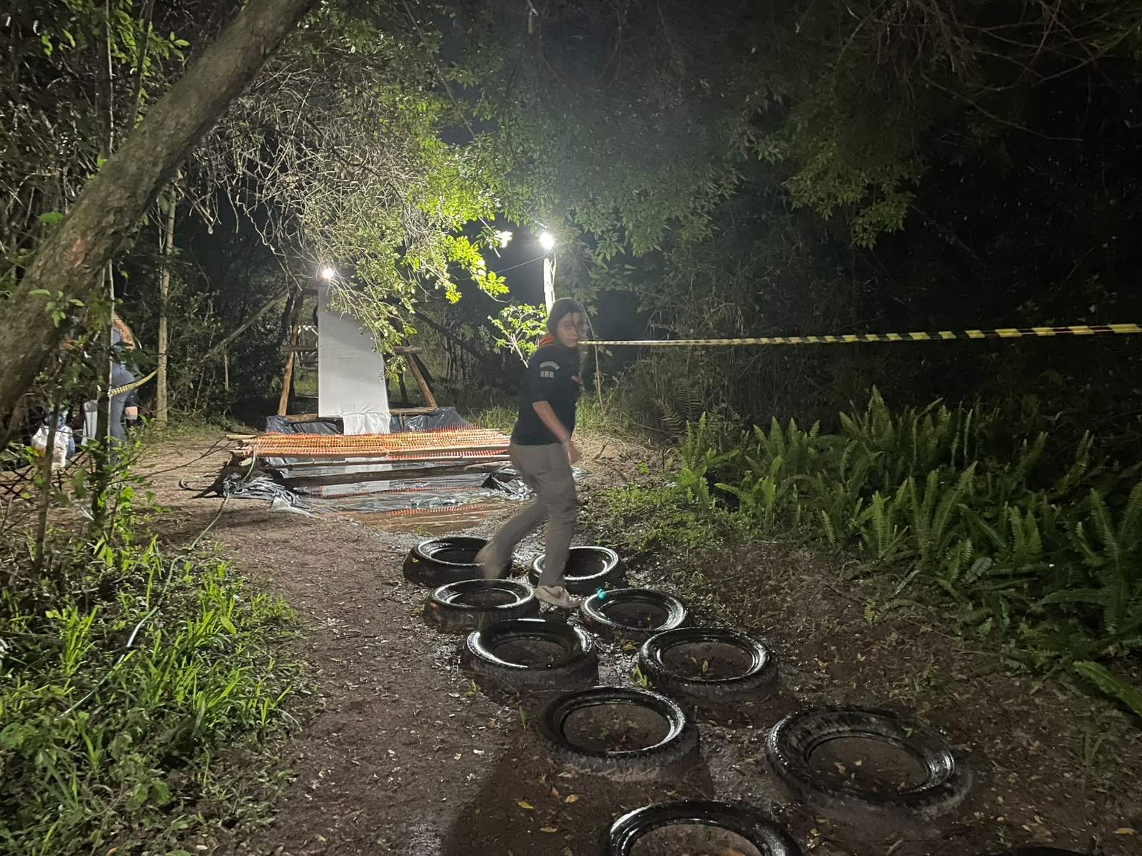 Sênior atravessando circuito de pneus à noite